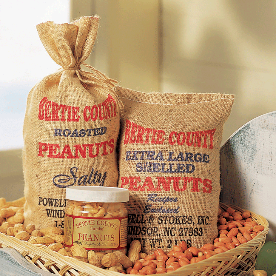 A wicker tray containing burlap bags filled with peanuts