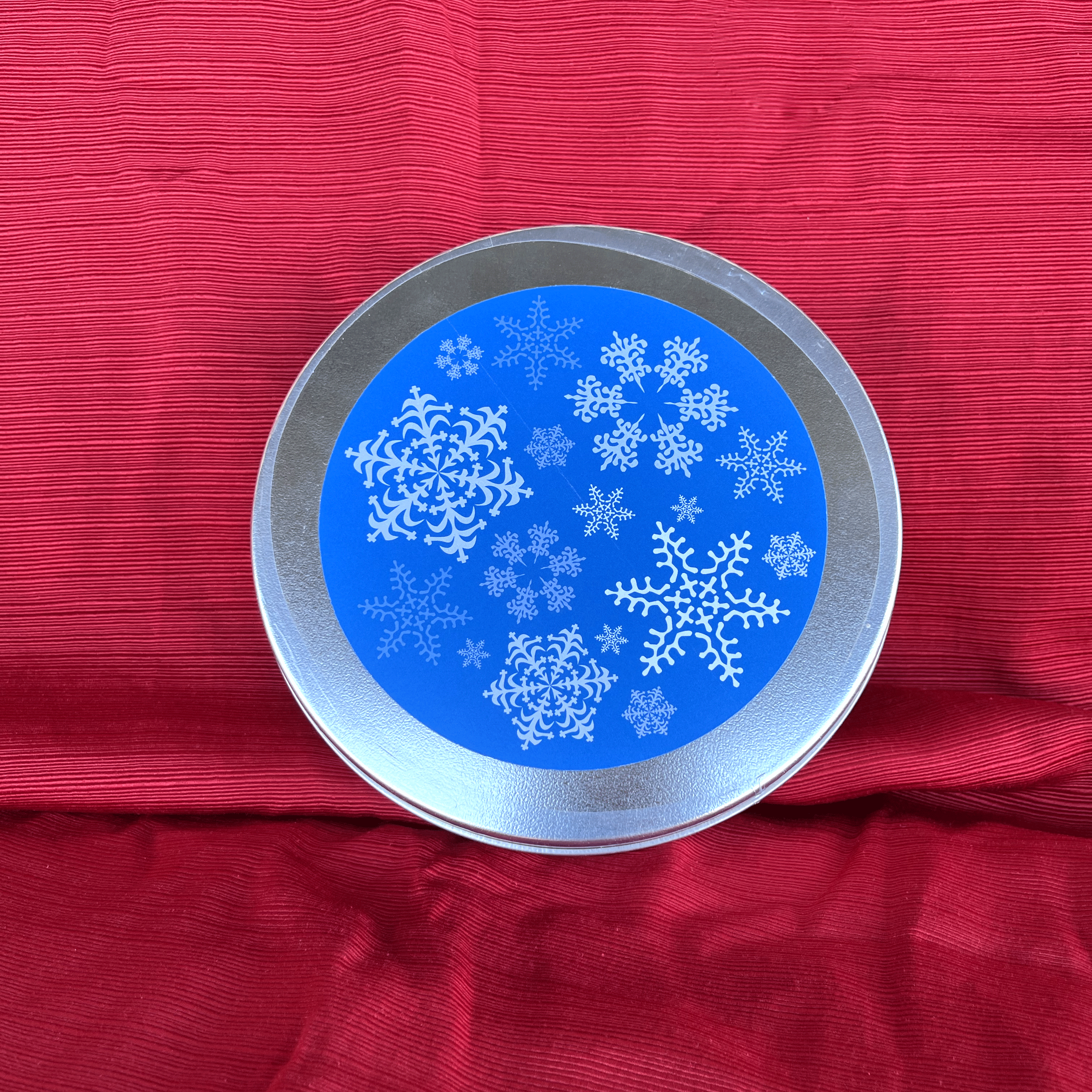 A tin with a blue snowflake pattern 